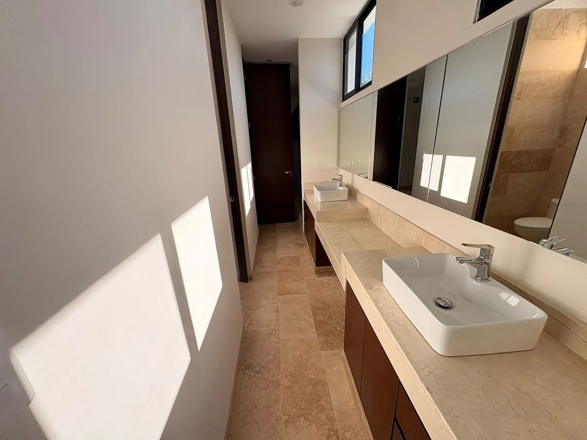 Baño secundario con cancel de cristal y acabados modernos