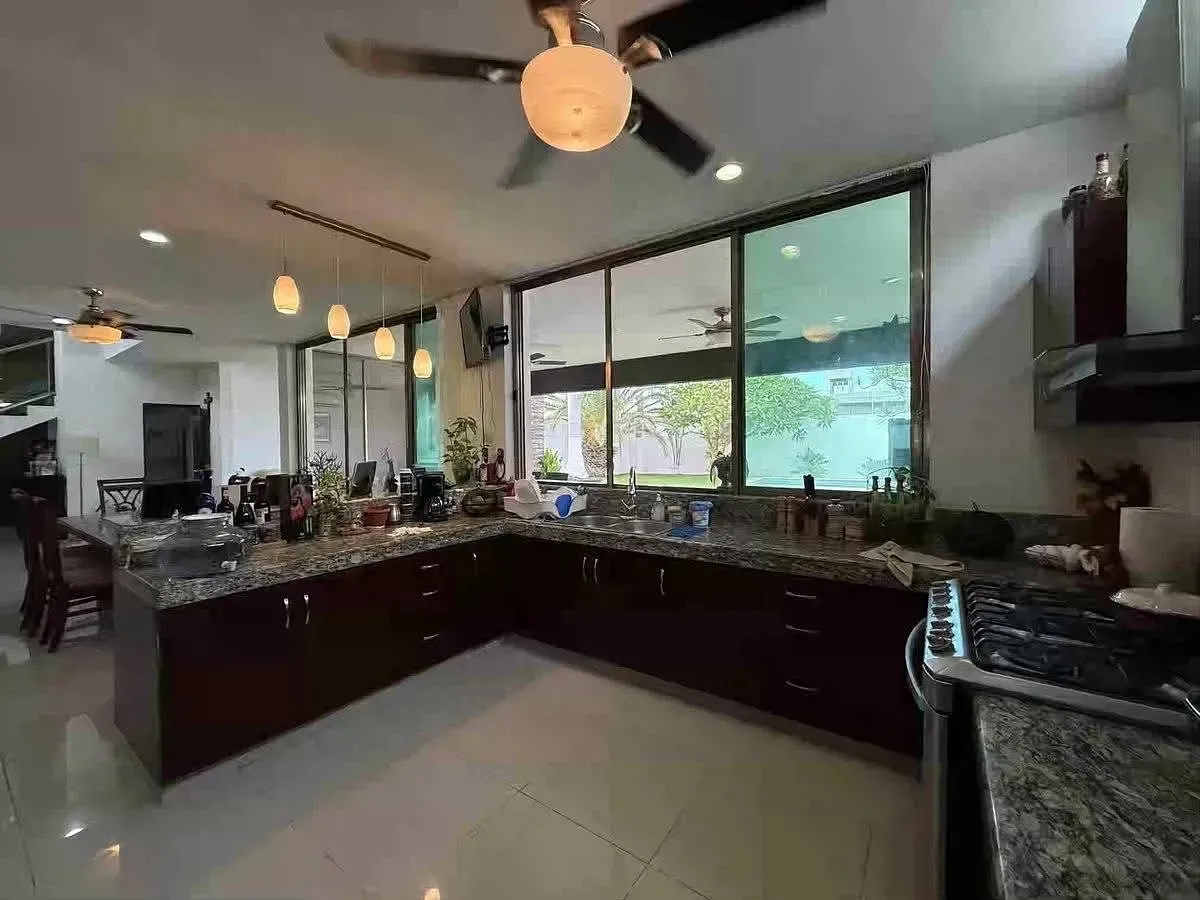 Cocina integral con barra de granito y gabinetes de madera