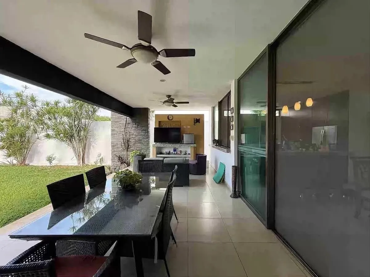 Terraza techada con área de asador y vista a la alberca